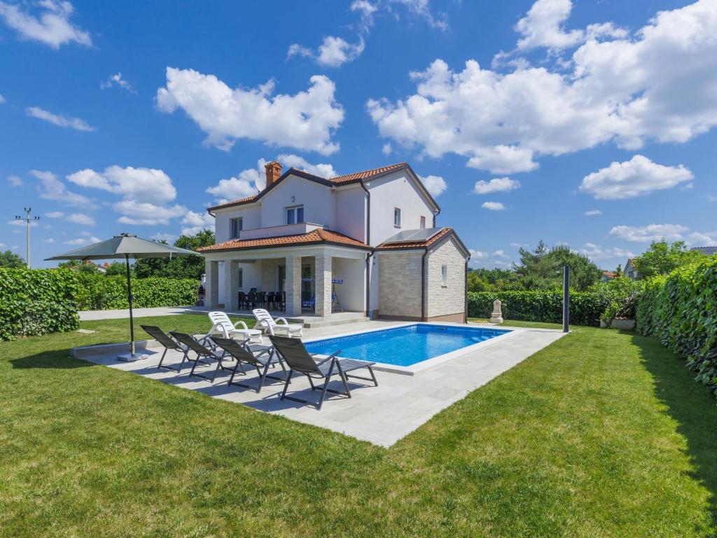 een villa met een zwembad en een gazon bij Holiday Home Villa Zirdum by Interhome in Nova Vas