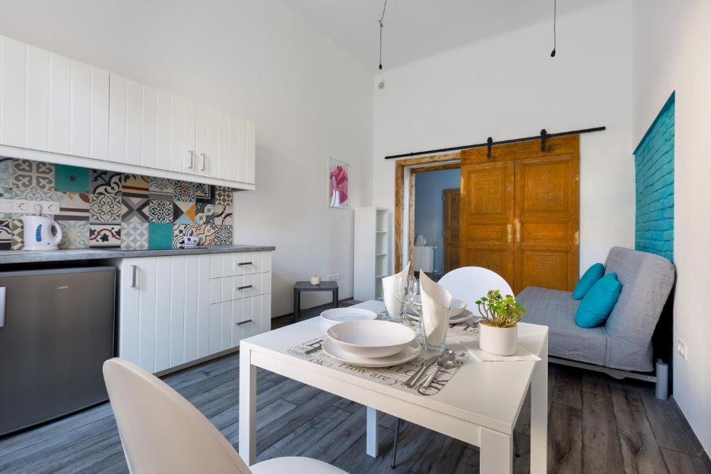 a kitchen and living room with a white table and chairs at J26 Jósika Apartment in Budapest