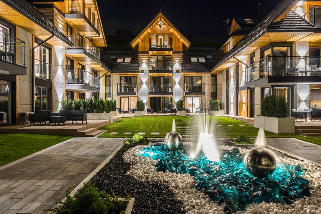 an exterior view of a building with a fountain at Aparthotel Prestige in Zakopane