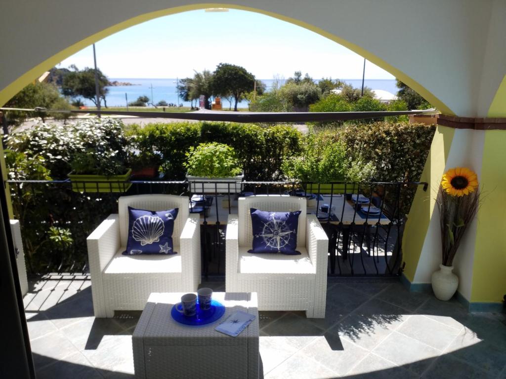 - un balcon avec deux chaises et une table avec vue dans l'établissement Villetta Il Faro sul Mare, à Àrbatax