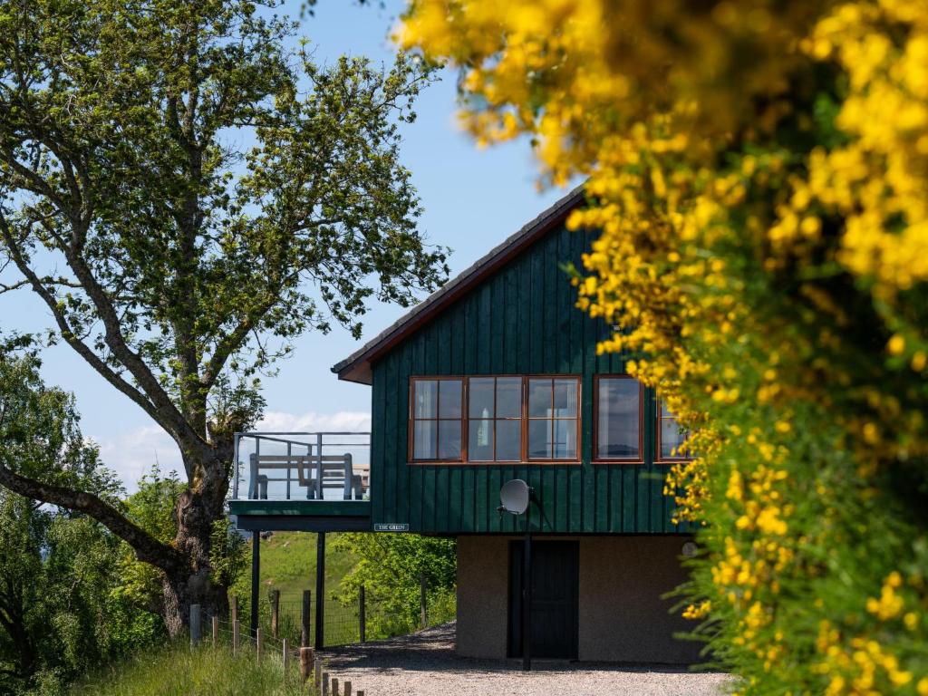 a green house with a balcony on top of it at Holiday Home Achmony Type 2-1 by Interhome in Drumnadrochit