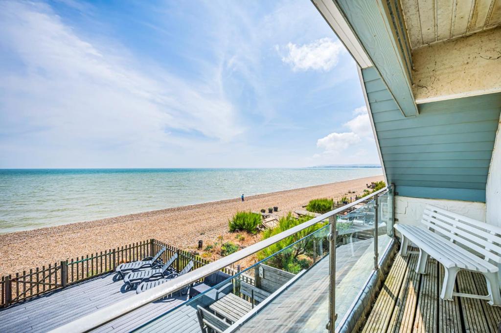 a balcony with a view of the beach at Beachfront Escape Sleeps 8 Ideal Family Retreat in Pevensey