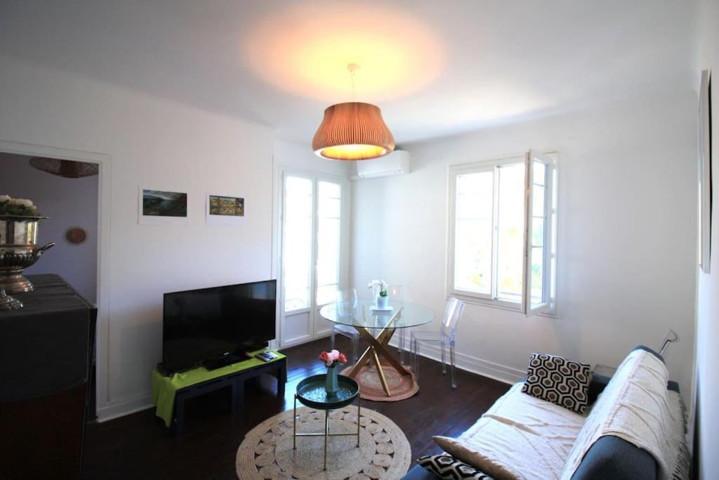 ein Wohnzimmer mit einem Sofa und einem TV in der Unterkunft Charming &amp; quiet appart 10 from beaches in Cannes