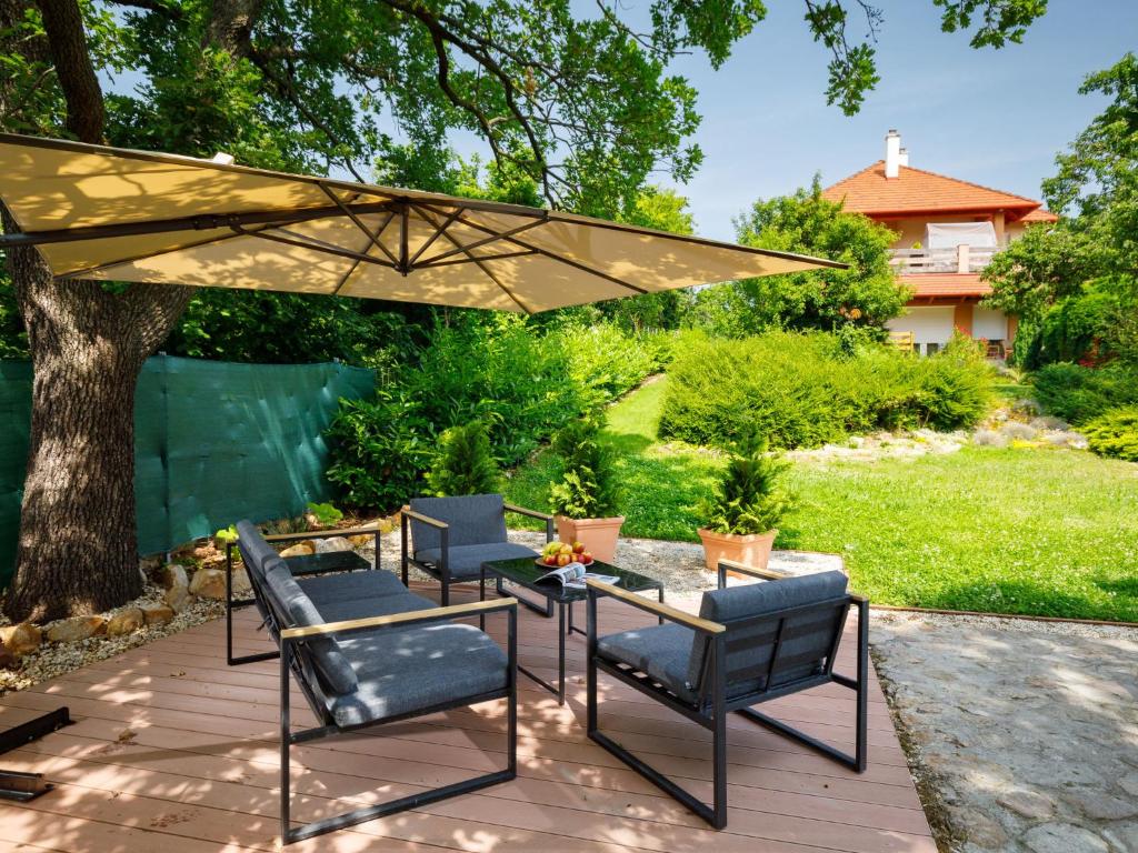 a patio with chairs and a table and an umbrella at Apartment Zen by Interhome in Révfülöp