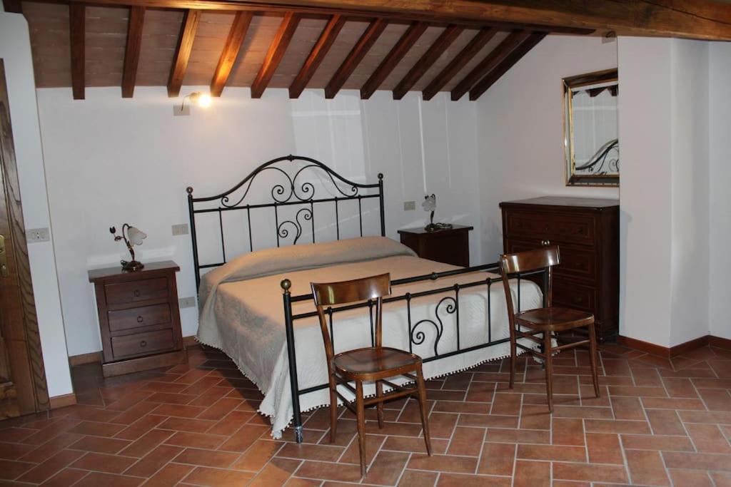 a bedroom with a bed with two chairs and a table at Casa dell'Ulivo in Pergognano