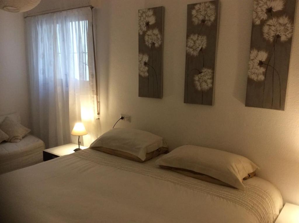a bedroom with a bed with two pillows and a window at Old town Marbella home in Marbella