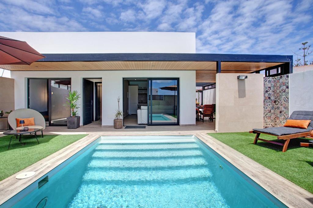 een huis met een zwembad in de tuin bij Villa Toro in Corralejo