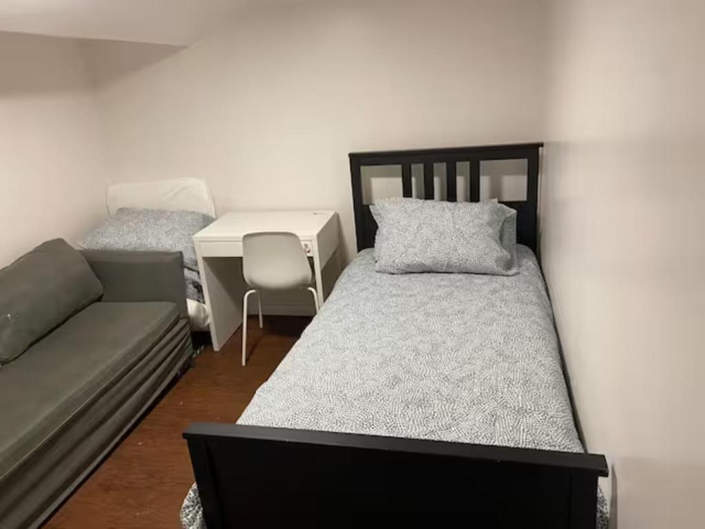 um pequeno quarto com uma cama e uma secretária em Private Basement Room 0363 em Toronto