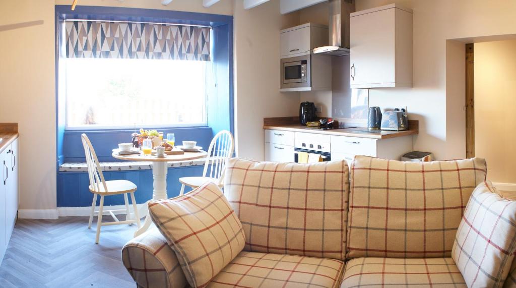Il comprend un salon avec un canapé et une cuisine avec une table. dans l'établissement The Annex Brook House Farm, Abbey views, Yorkshire Coast Holiday Lets, à Whitby