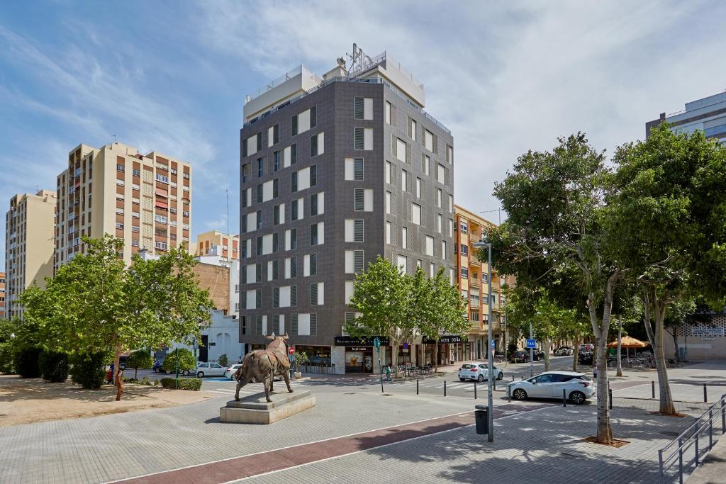 una estatua de una vaca en una ciudad con edificios en Doña Lola, en Castellón de la Plana