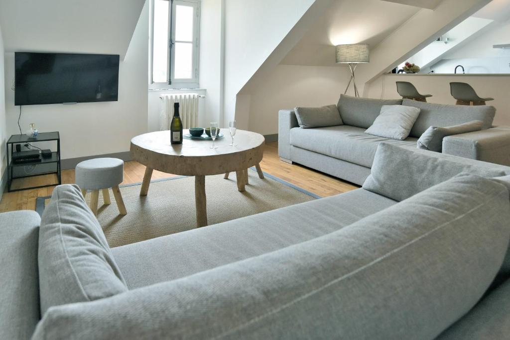 uma sala de estar com dois sofás e uma mesa em Le Sainte Catherine - Appt centre-historique em Dinan