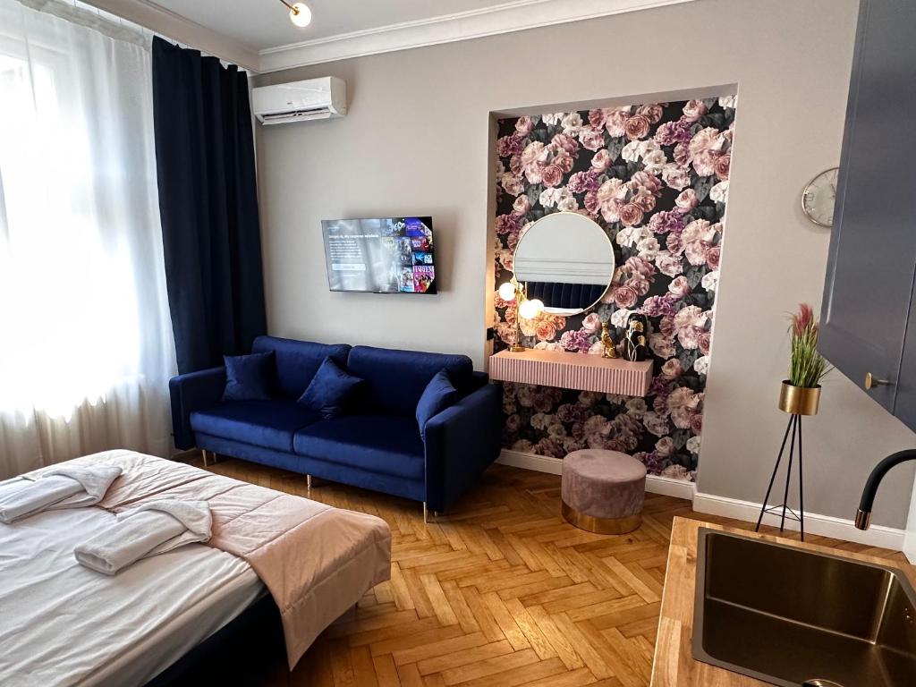 a bedroom with a blue couch and a mirror at Premium Apartment in Spiski Palace in Krakow