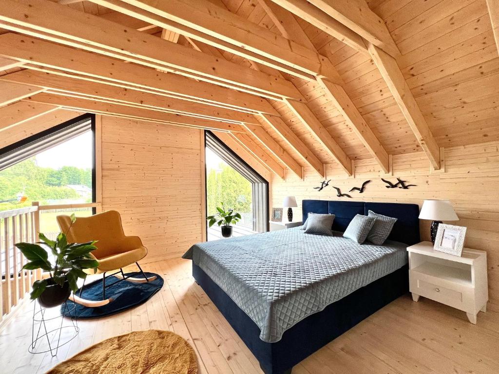 1 dormitorio con 1 cama y 1 silla en una habitación en DUO Dom Kopalino, en Kopalino