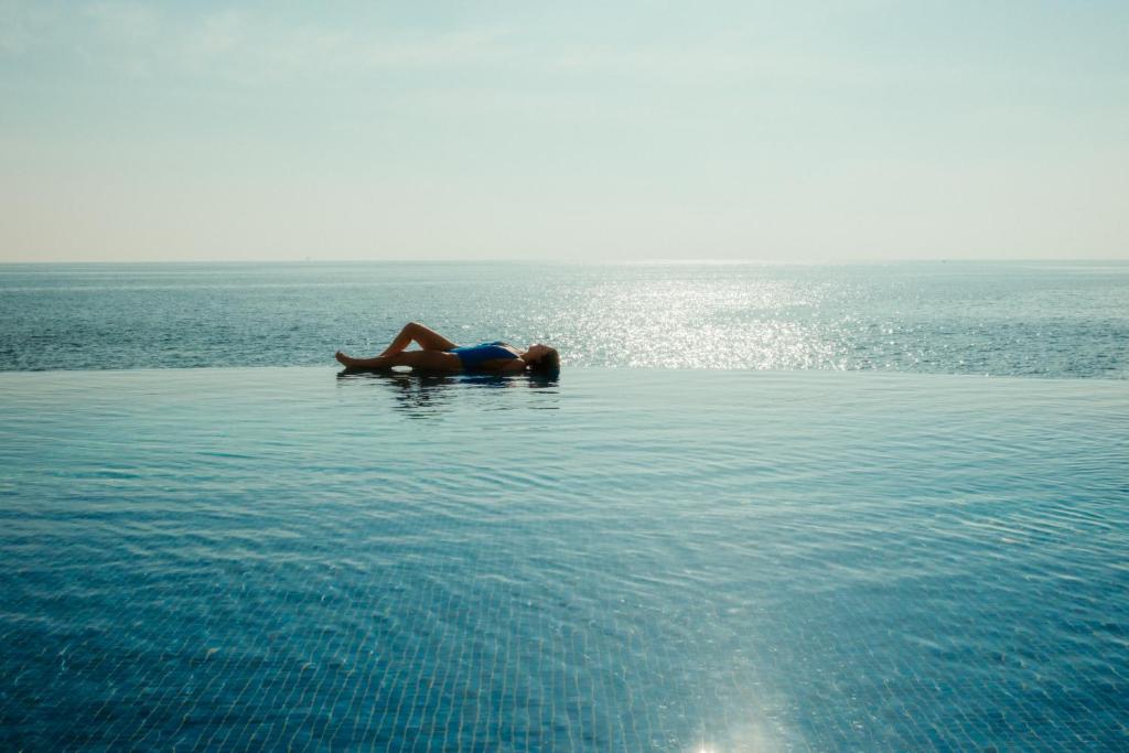 a woman laying in the water in the ocean at 1926 Le Soleil Hotel & Spa in Sliema