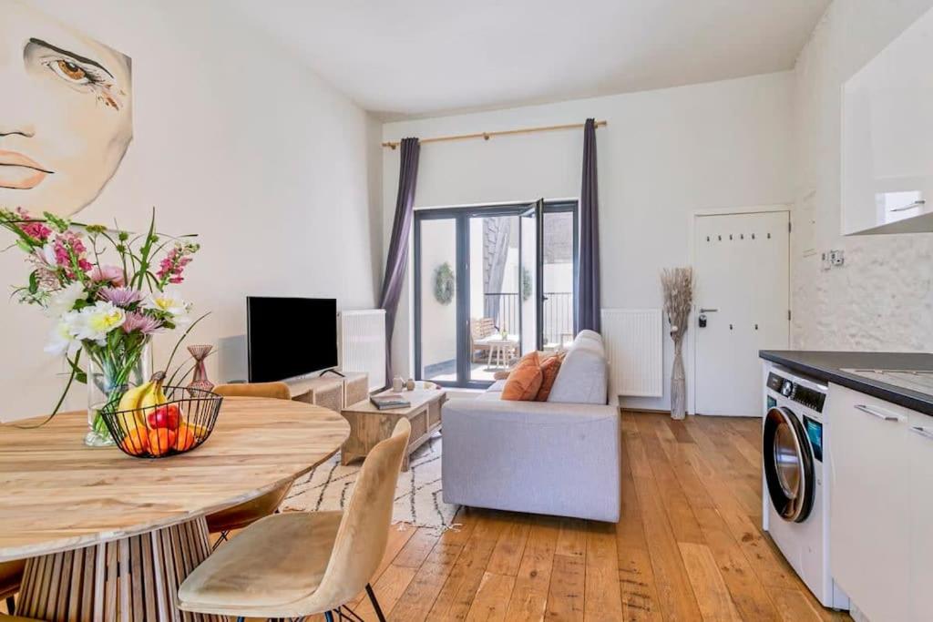 uma cozinha e uma sala de estar com uma mesa e um sofá em Wonderful apartment in the center of Antwerp em Antuérpia
