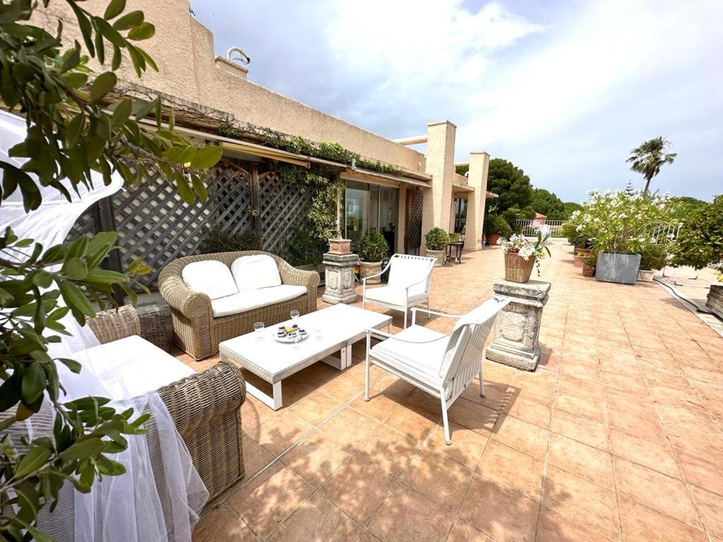 patio z wiklinowymi meblami, stołem i krzesłami w obiekcie Panoramic sea view penthouse with jacuzzi and 450 sqm terrace w mieście Antibes