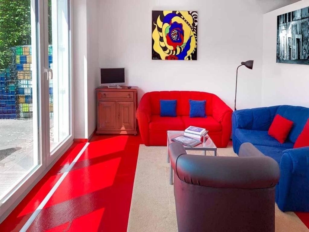 sala de estar con sofás rojos y azules y TV en Gemütliche Wohnung in Bullay mit Grill, Garten und Terrasse - unikum-Ferienwohnung Perle-Lollipop, en Bullay