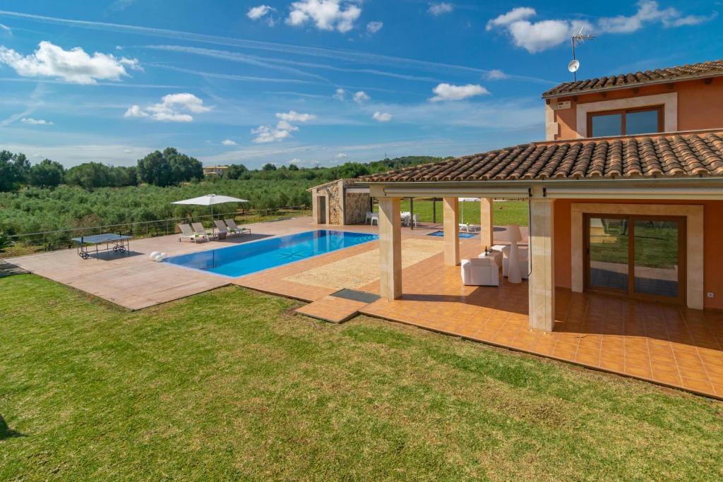un patio trasero con piscina y una casa en Son Morei de Ses Penyes, en Muro