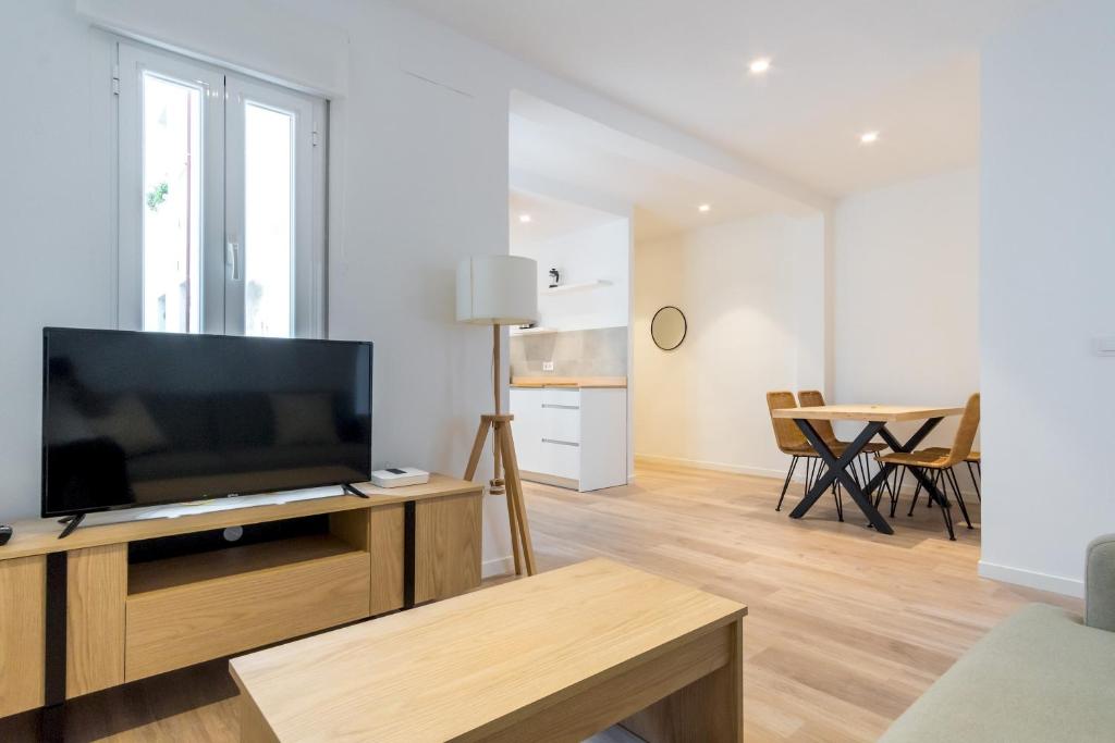 een woonkamer met een televisie en een tafel bij Bright Modern - 2Bedrooms 1Bathroom - Delicias in Madrid