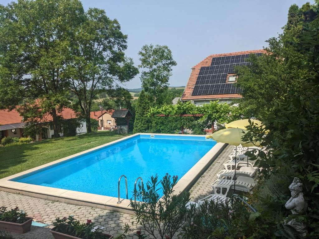 a swimming pool in a yard with a solar roof at Guest house Magyar Route 66 in Szilvásvárad