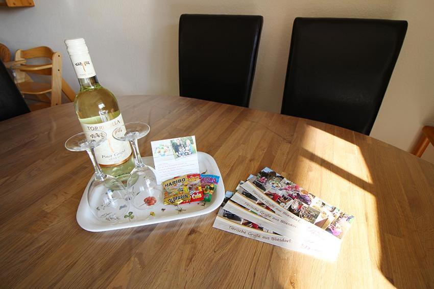 eine Flasche Wein auf einem Tablett auf dem Tisch in der Unterkunft Seerose in Bliesdorf