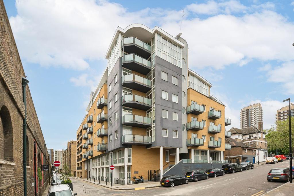 a tall apartment building on a city street at Pass the Keys Stunning balcony apartment - Central East London in London