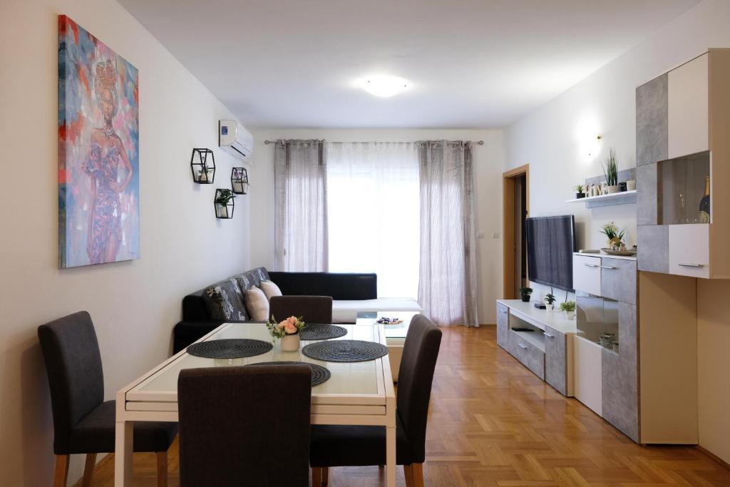 sala de estar con mesa y sala de estar con sofá en Apartman Nane, en Kaštela