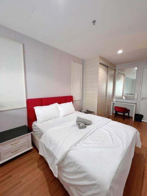 una camera da letto con un grande letto bianco con testiera rossa di Cozy Staycation @ ICITY near SOGO & Central I-City a Shah Alam