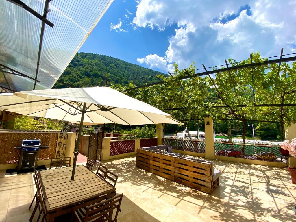 Appartement terrasse vue lac في بريل-سور-رويا: فناء مع طاولة ومظلة