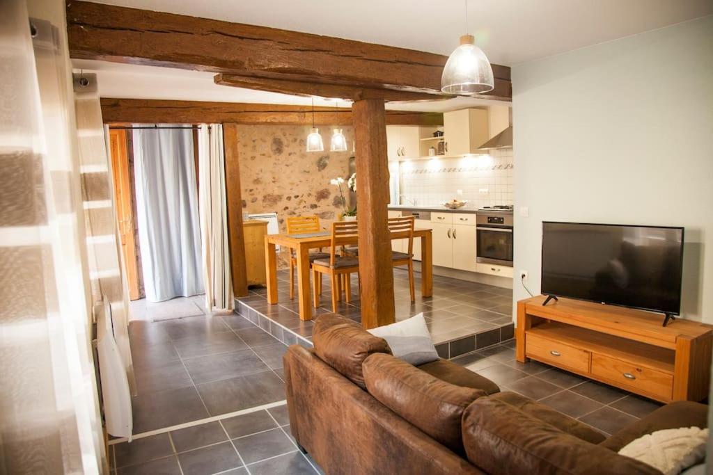 sala de estar con sofá marrón y cocina en Gîte „La maison des épices“, en Kintzheim