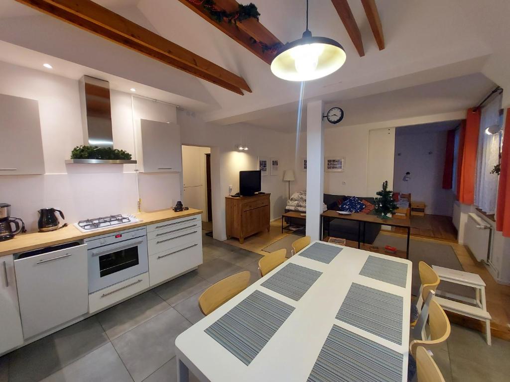 cocina y sala de estar con mesa y sillas en Apartament Roland, en Świeradów-Zdrój