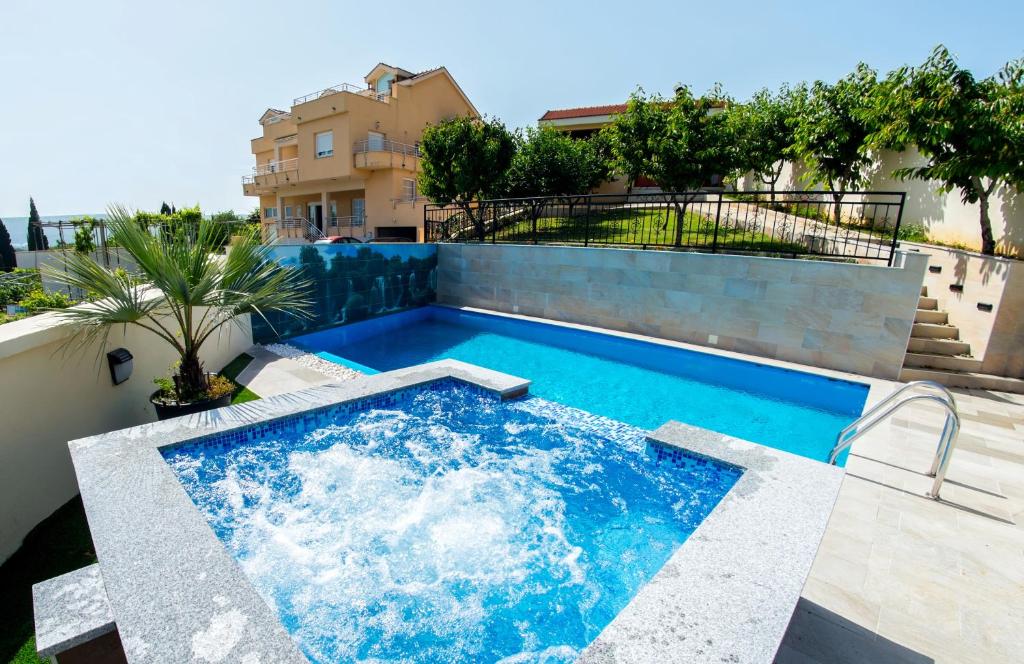 Luxury Villa with Private Pool and Jacuzzi في Gnojnice: مسبح على جانب مبنى