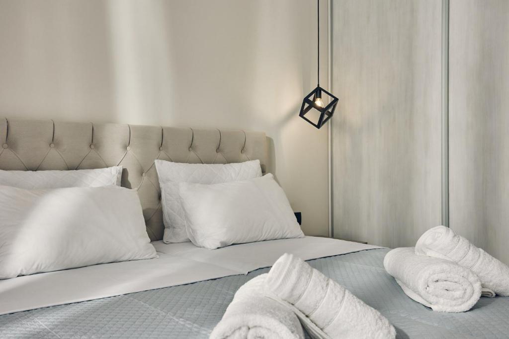 a bedroom with a bed with white pillows at Mouzaki's Stone Villas in Volímai