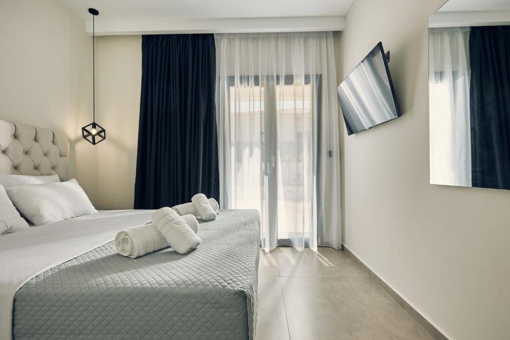 a bedroom with a bed with towels on it at Mouzaki's Stone Villas in Volímai