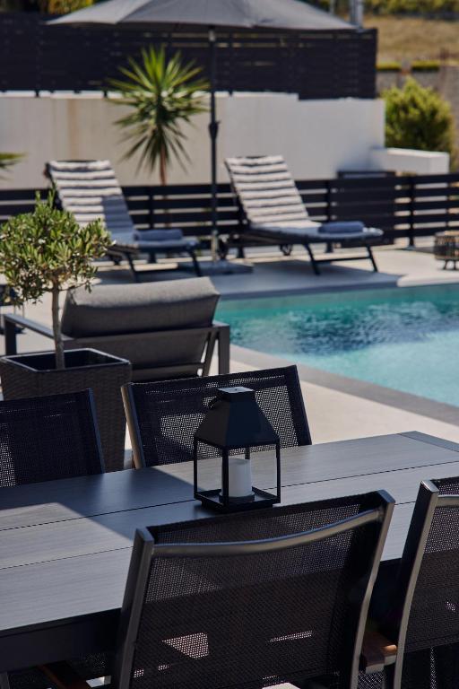 a table and chairs next to a swimming pool at Mouzaki's Stone Villas in Volímai