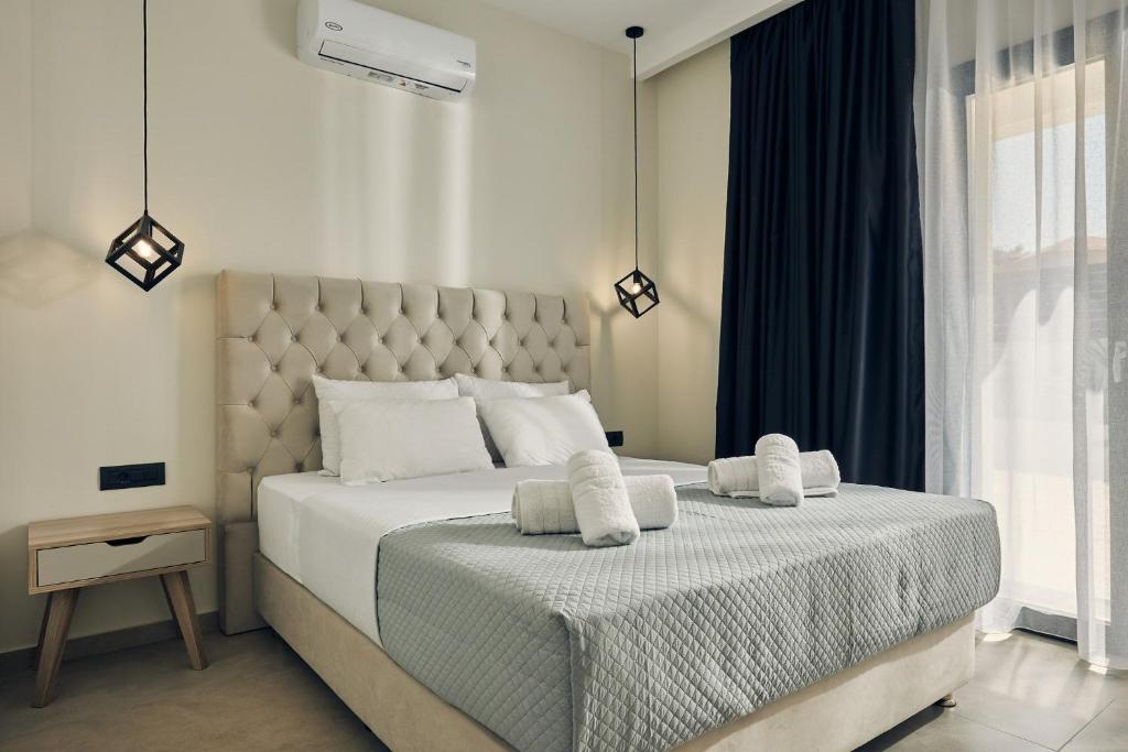 a bedroom with a large bed with towels on it at Mouzaki's Stone Villas in Volímai