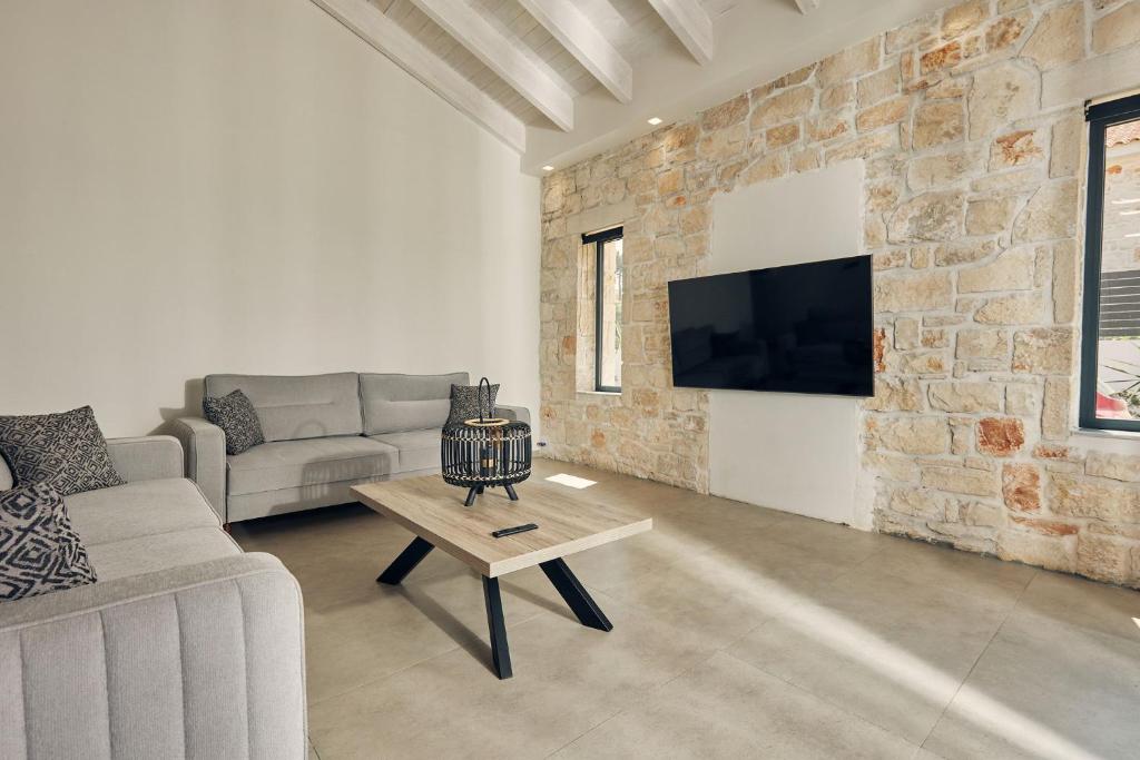 a living room with a couch and a table at Mouzaki's Stone Villas in Volímai
