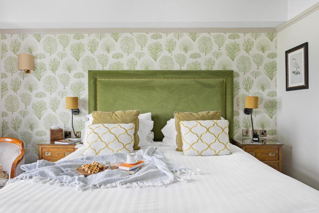 a bedroom with a white bed with a green headboard at Thurlestone Hotel in Thurlestone