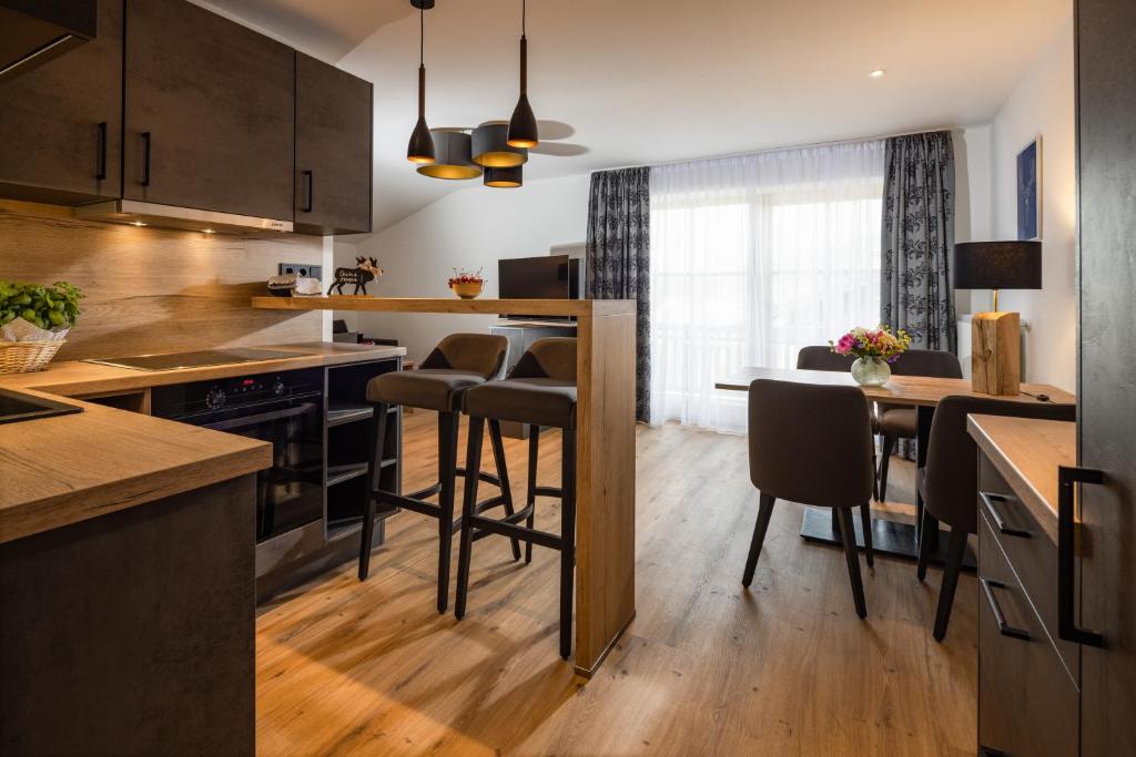 uma cozinha com uma mesa e algumas cadeiras em Hubertus Appartements Inzell em Inzell