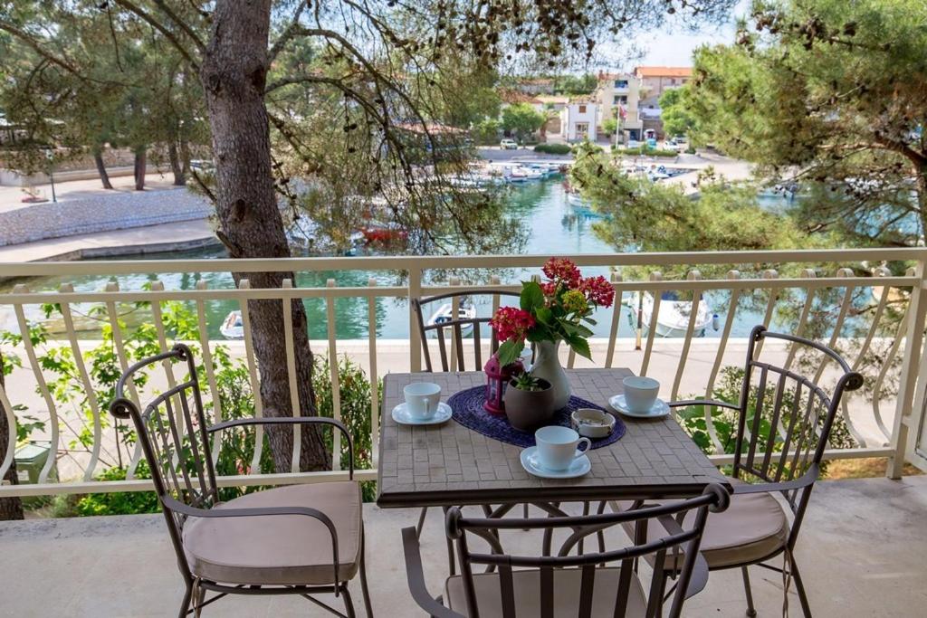 a table with flowers on a balcony with a view of a river at House Dinka with Pool in Porat