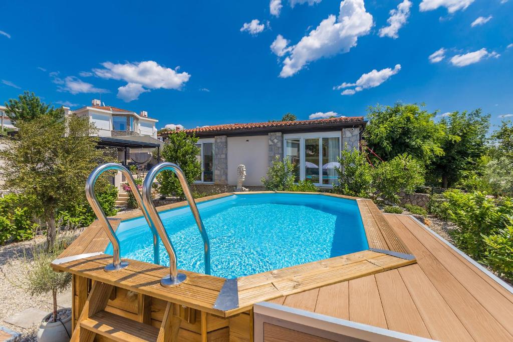 a swimming pool on a wooden deck next to a house at Kuća za odmor Villa Seahorse in Pinezici