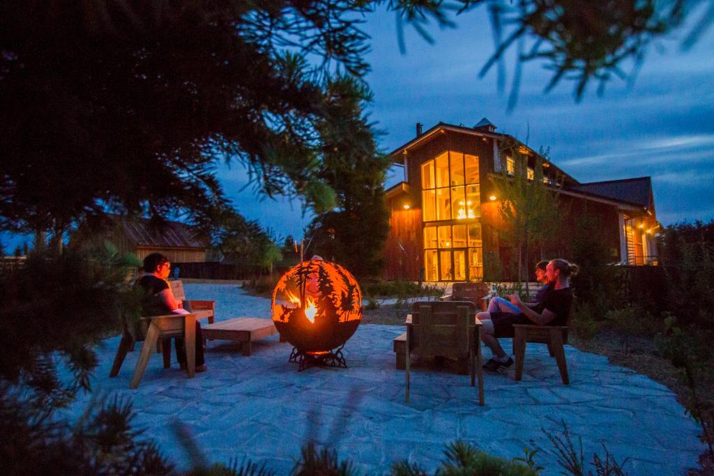 un groupe de personnes assises dans une cour la nuit dans l'établissement Parc Animalier de Sainte-Croix, à Rhodes