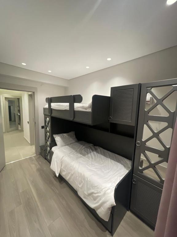 1 dormitorio con 2 literas con sábanas blancas en Milpark suites, en Estambul