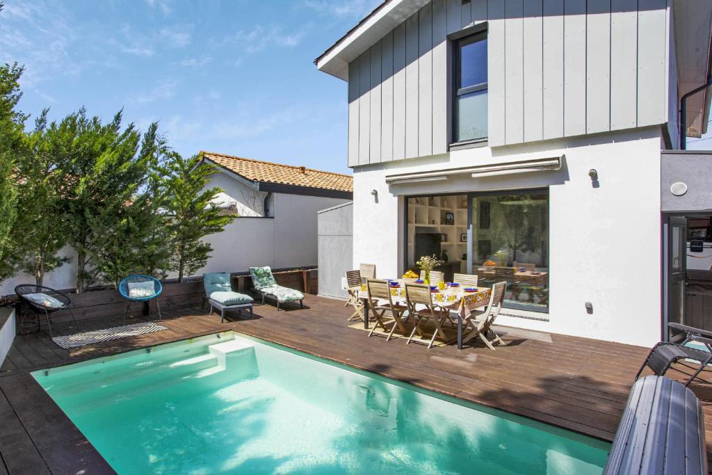 a backyard with a swimming pool and a house at Beautiful villa with heated swimming pool - Biarritz - Welkeys in Biarritz