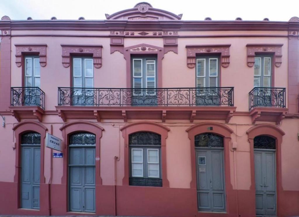 ein rosafarbenes Gebäude mit Balkon darüber in der Unterkunft Casa Colonial Cejas in Santa Cruz de Tenerife