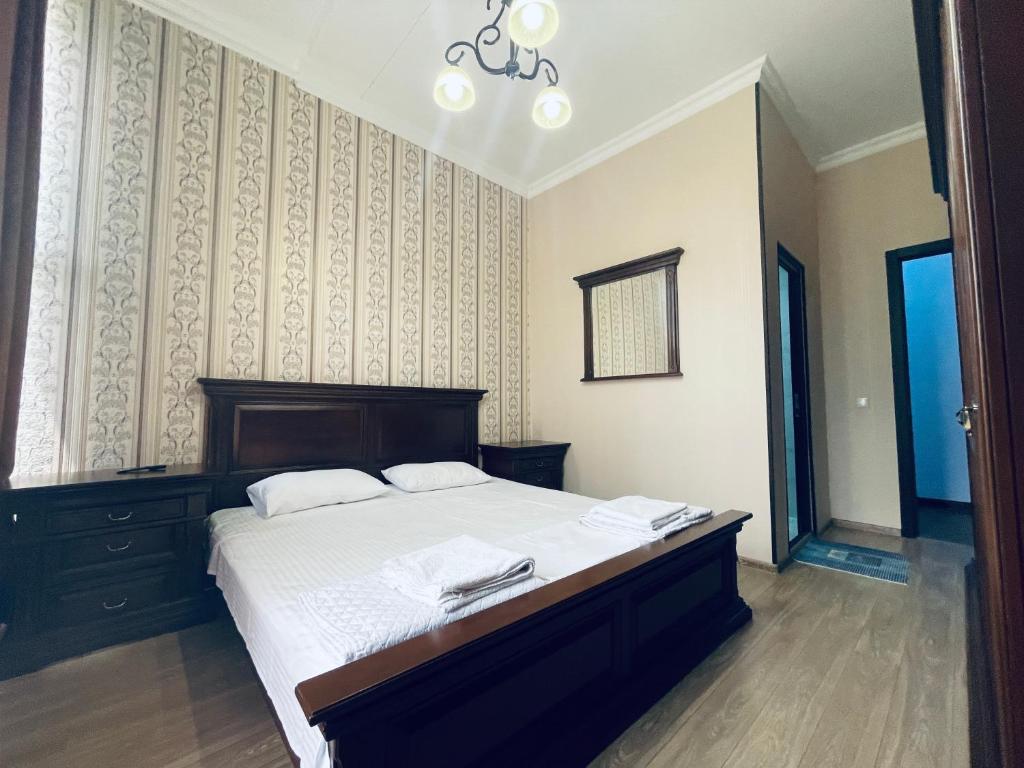 um quarto com uma cama grande e lençóis brancos em HOTEL AiSi აისი em Kutaisi