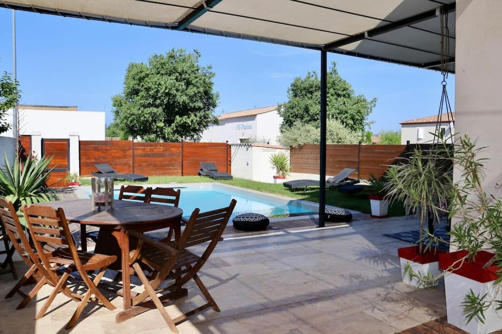 un patio avec une table et des chaises et une piscine dans l'établissement Villa llolan, à Saint-Rémy-de-Provence