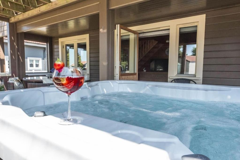 a glass of wine next to a hot tub at Mallards' Rest in Fritton
