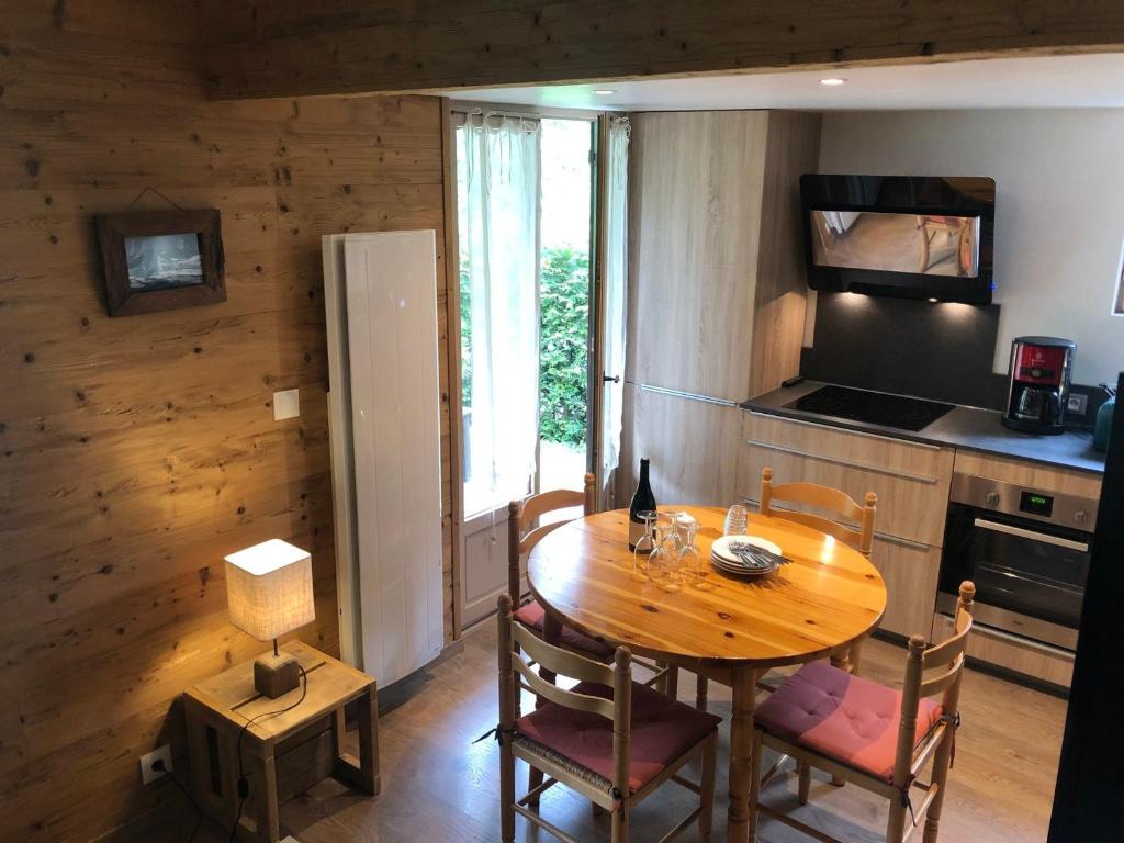 a kitchen with a wooden table with chairs and a refrigerator at Chalet Barcelonnette, 4 pièces, 6 personnes - FR-1-165A-145 in Barcelonnette