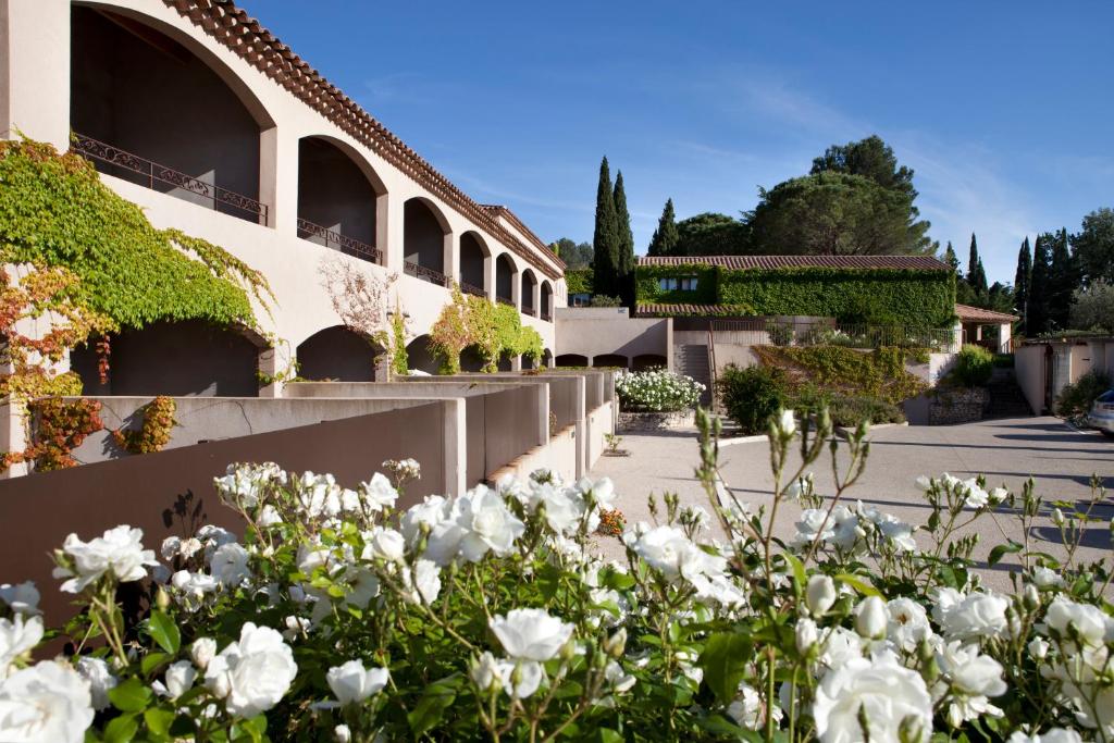 a building with white flowers in front of it at Résidence Le Mas de Valrugues (by Popinns) in Saint-Rémy-de-Provence